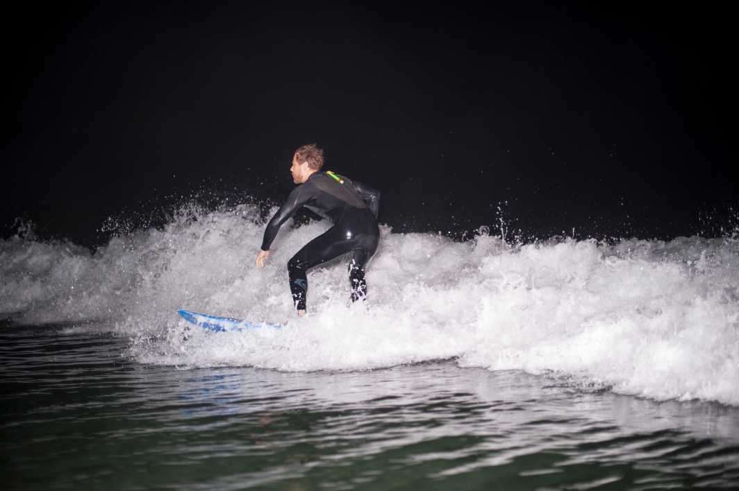Night surfing flash inside wave